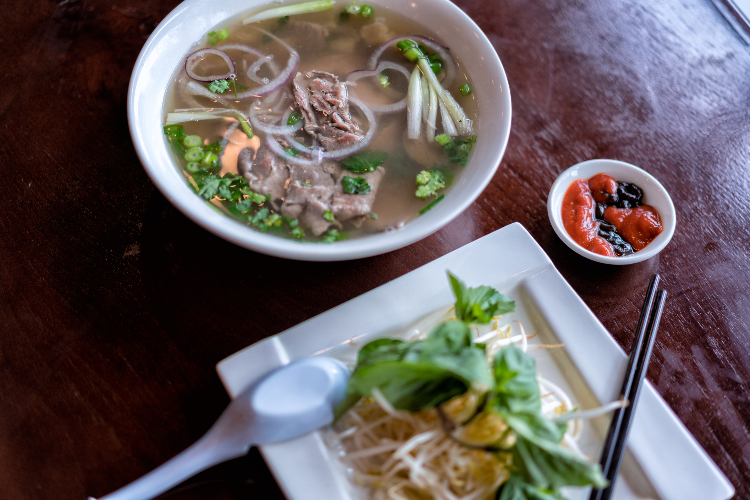 a bowl of soup and chopsticks on a table
