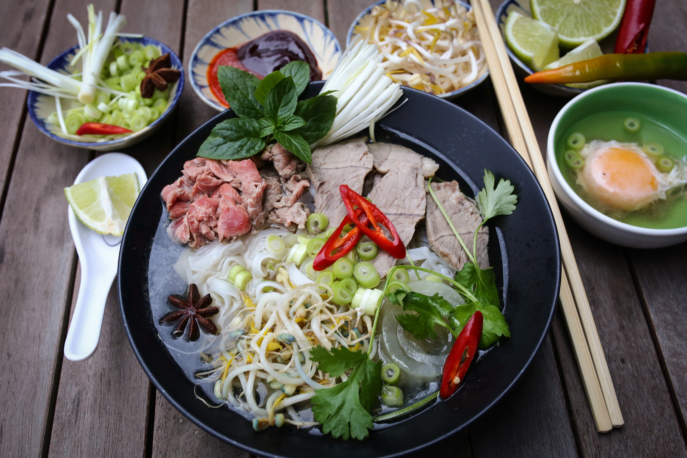 a bowl of Vietnamese food on a wooden table